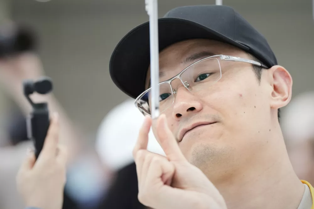An attendee takes a closer look at the iPhone Air during an announcement of new products at Apple Park on Tuesday, Sept. 9, 2025, in Cupertino, Calif. (AP Photo/Godofredo A. Vásquez)
