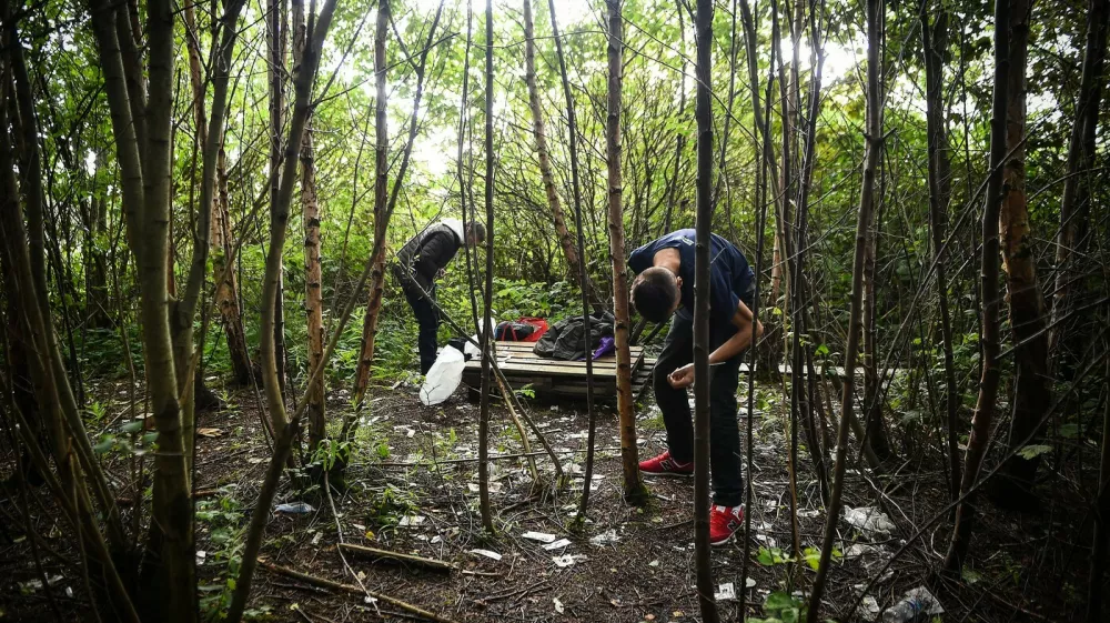 Drug addict Michael (R) is seen preparing to inject cocaine in a small wooded area used by addicts to take drugs near Glasgow city centre, Scotland, on August 15 2019. Drug addict Michael arrives at a derelict scrap of land near Glasgow city centre littered with used syringes and other drug detritus to inject cocaine. He is helped by a fellow user who quickly mixes the white powder with distilled water in a small spoon and draws the liquid up into two needles. Moments later, the pair, barely hidden in the wasteland site, drop their trousers and shoot the narcotic-laced fluid into their leg veins. The pair are examples of worsening drug misuse across Scotland, where drug-related death rates are now among the worst in the developed world.,Image: 468832569, License: Rights-managed, Restrictions: TO GO WITH AFP STORY BY JOE JACKSON, Model Release: no