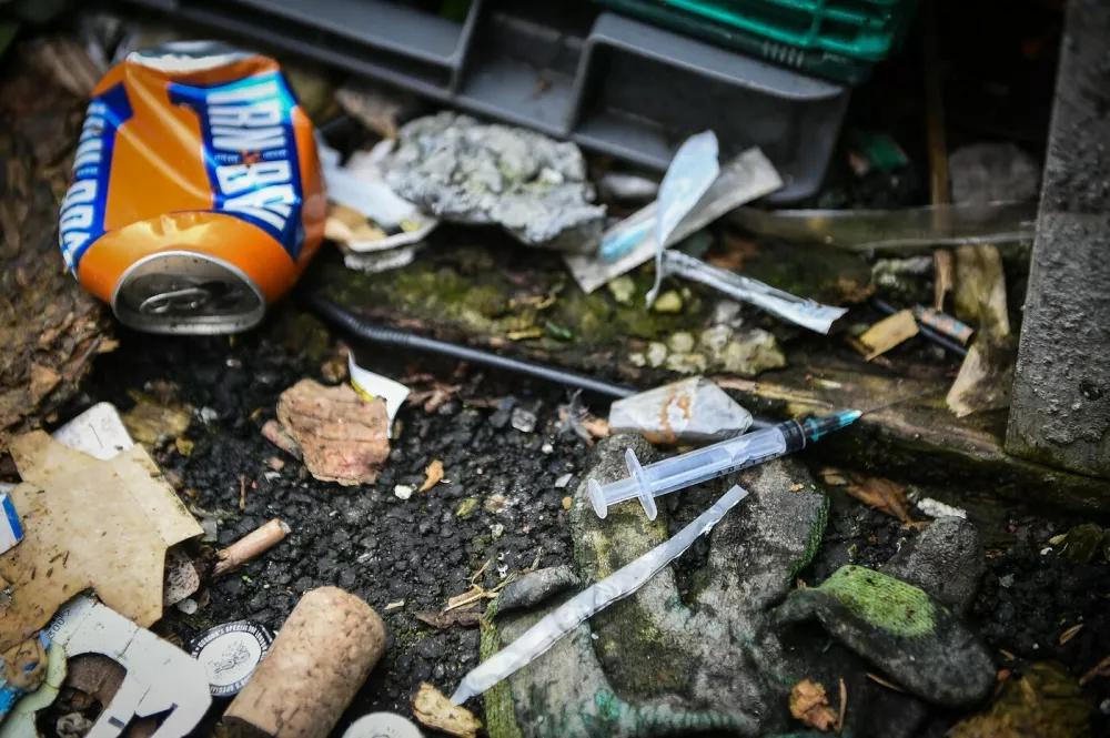A picture shows discarded drug paraphenallia in a small wooded area used by addicts to take drugs near Glasgow city centre, Scotland, on August 15 2019. Drug addict Michael arrives at a derelict scrap of land near Glasgow city centre littered with used syringes and other drug detritus to inject cocaine. He is helped by a fellow user who quickly mixes the white powder with distilled water in a small spoon and draws the liquid up into two needles. Moments later, the pair, barely hidden in the wasteland site, drop their trousers and shoot the narcotic-laced fluid into their leg veins. The pair are examples of worsening drug misuse across Scotland, where drug-related death rates are now among the worst in the developed world.,Image: 468832576, License: Rights-managed, Restrictions: TO GO WITH AFP STORY BY JOE JACKSON, Model Release: no
