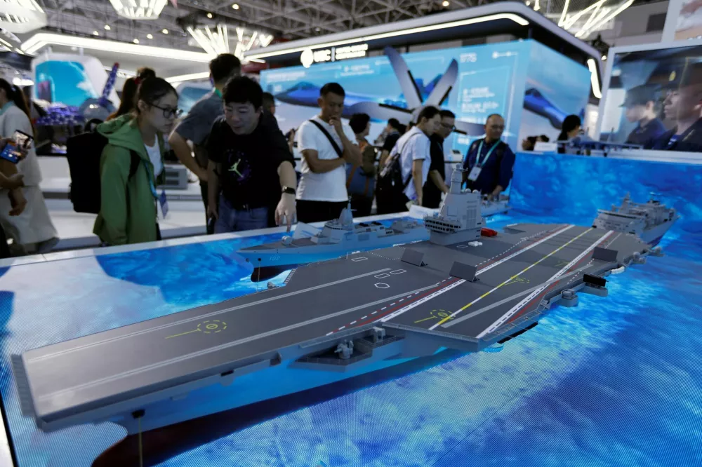 FILE PHOTO: Visitors look at a model of the Fujian Type 003 aircraft carrier displayed at the China International Aviation and Aerospace Exhibition, or Airshow China, in Zhuhai, Guangdong province, China November 14, 2024. REUTERS/Tingshu Wang/File Photo