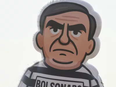 University students display an inflatable doll of Brazil's former President Jair Bolsonaro wearing prisoner garb in Brasilia, Brazil, Friday, Sept. 12, 2025, the morning after the Supreme Court convicted and sentenced him to prison for attempting a coup to remain in office despite his 2022 electoral defeat. (AP Photo/Eraldo Peres)