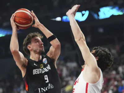 Germany's Franz Wagner, left, tries to score as Turkey's Cedi Osman blocks him during the Eurobasket, European Basketball Championship final match between Turkey and Germany at the Riga Arena in Riga, Latvia, Sunday, Sept. 14, 2025. (AP Photo/Sergei Grits)
