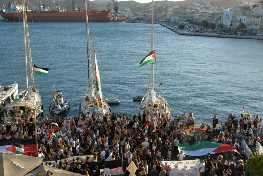 A Palestinian flag is seen as people gather at the port of Ermoupolis before the departure of two sailing boats, Electra and Oxygen, part of the Global Sumud Flotilla aiming to reach Gaza and break Israel's naval blockade, on Syros island, Greece, September 14, 2025. REUTERS/Giorgos Solaris