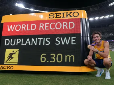 World Athletics Championships Tokyo 2025 - Men's Pole Vault Final - Japan National Stadium, Tokyo, Japan - September 15, 2025 Sweden's Armand Duplantis poses next to the scoreboard as he celebrates with his medal after winning gold and breaking the world record in the final REUTERS/Aleksandra Szmigiel