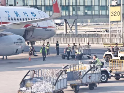 Chinese ground engineering crew prepare a Sichuan Airlines' Airbus A320 neo airplane for take-off on the tarmac of Beijing Capital International Airport (IATA: PEK, ICAO: ZBAA), Chaoyang&acirc;&euro;"Shunyi, China. Sichuan Airlines Co., Ltd. is a Chinese airline based in Chengdu Shuangliu International Airport in Chengdu, Sichuan Province, and is the largest airline in western China