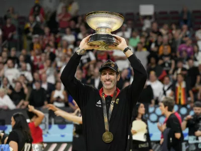 Basketball - FIBA EuroBasket 2025 - Final - Turkey v Germany - Xiaomi Arena, Riga, Latvia - September 14, 2025 Germany head coach Alex Mumbru holds the trophy after winning the FIBA EuroBasket final REUTERS/Ints Kalnins