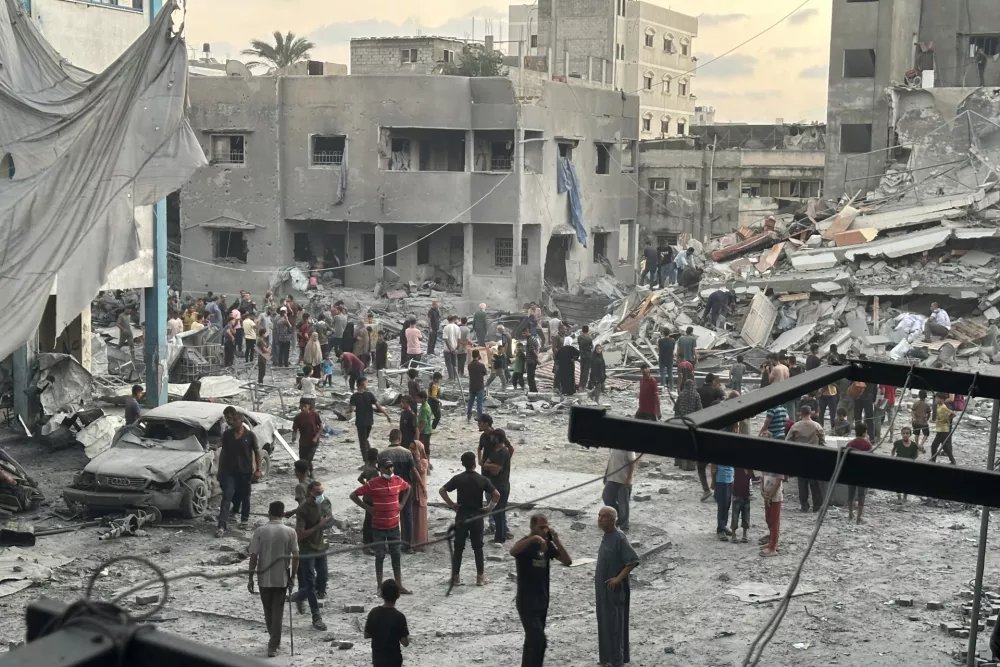 15 September 2025, Palestinian Territories, Gaza: People gather outside a building damaged in an Israeli airstrike west of Gaza City. Photo: Hasan Alzaanin/TASS via ZUMA Press/dpa