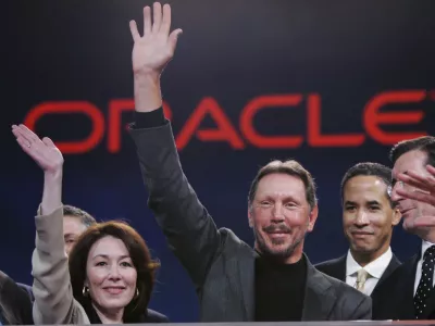 Oracle CEO Larry Ellison, center, smiles with Oracle CFO Safra Catz, left, and Oracle president Charles Phillips, second from right, during the Oracle Open World conference in San Francisco, Wednesday, Oct. 25, 2006. Oracle Corp. is scheduled to report fiscal second-quarter earnings after the bell. (AP Photo/Paul Sakuma)