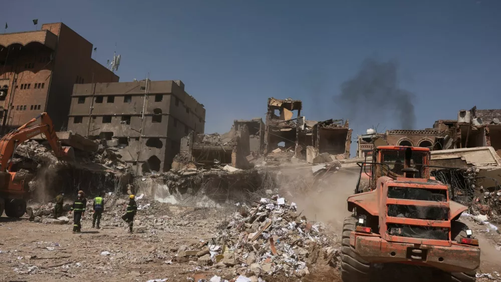 Members of civil defence stand as a bulldozer removes debris from the site of Wednesday's Israeli airstrikes, in Sanaa, Yemen September 14, 2025. REUTERS/Khaled Abdullah