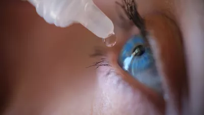 Woman applying eye drops to eye. Eye care and beauty concept.