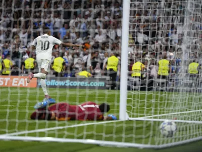 Real Madrid's Kylian Mbappe, top, celebrates after scoring past Marseille's goalkeeper Geronimo Rulli his side's second goal during a Champions League opening phase soccer match between Real Madrid and Marseille at Santiago Bernabeu stadium, in Madrid, Tuesday, Sept. 16, 2025. (AP Photo/Manu Fernandez)