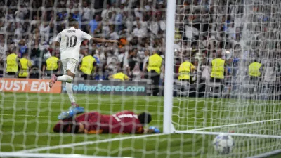Real Madrid's Kylian Mbappe, top, celebrates after scoring past Marseille's goalkeeper Geronimo Rulli his side's second goal during a Champions League opening phase soccer match between Real Madrid and Marseille at Santiago Bernabeu stadium, in Madrid, Tuesday, Sept. 16, 2025. (AP Photo/Manu Fernandez)