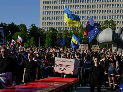 A figure with a box painted with a cartoon depicting Slovakian Prime Minister Robert Fico sits at a table covered in red material, representing blood, at an art performance held during an anti-government protest, in Bratislava, Slovakia, May 9, 2025. REUTERS/Radovan Stoklasa