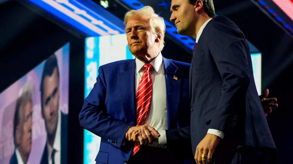 FILE PHOTO: U.S. President-elect Donald Trump shakes hands with Turning Point USA founder Charlie Kirk, at Turning Point USA's AmericaFest in Phoenix, Arizona, U.S., December 22, 2024. REUTERS/Cheney Orr//File Photo