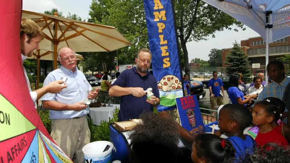Ben Cohen, second from left, and Jerry Greenfield, center, founders of Ben & Jerry Homemade Inc., serve ice cream to Washington residents July 12, 2006, to kick off a federal budgets priority campaign. (AP Photo/Nick Wass)