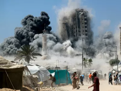 REFILE - ADDING NAME OF TOWER HIT IN AN ISRAELI STRIKE ON SEPTEMBER 5, 2025. Palestinians run as the 15-story Mushtaha Tower collapses after being hit by an Israeli air strike, in Gaza City, September 5, 2025. REUTERS/Mahmoud Issa   TPX IMAGES OF THE DAY