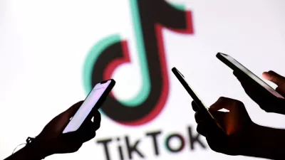 FILE PHOTO: Teenagers pose for a photo while holding smartphones in front of a TikTok logo in this illustration taken September 11, 2025. REUTERS/Dado Ruvic/Illustration/File Photo