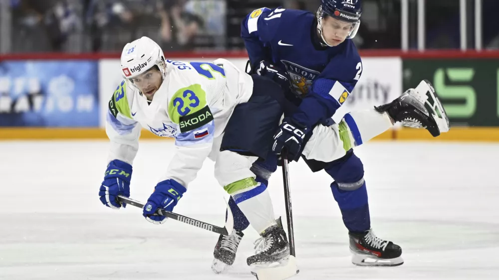 Slovenia's Jaka Sodja, left, and Finland's Patrik Puistola, right, challenge for the puck during the IIHF Ice Hockey World Championship group A match between Finland and Slovenia in Stockholm, Sweden, Thursday, May 15, 2025. (Anders Wiklund/TT News Agency via AP)