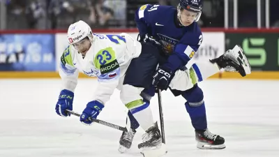 Slovenia's Jaka Sodja, left, and Finland's Patrik Puistola, right, challenge for the puck during the IIHF Ice Hockey World Championship group A match between Finland and Slovenia in Stockholm, Sweden, Thursday, May 15, 2025. (Anders Wiklund/TT News Agency via AP)
