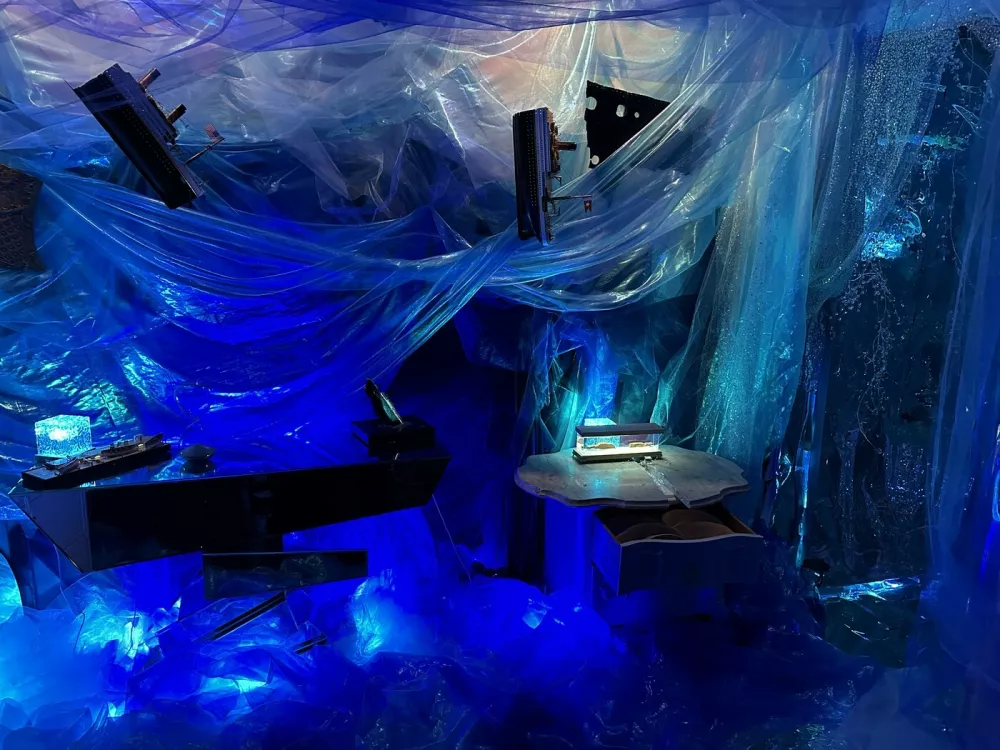 Story from Jam Press (Titanic Decorated Apartment)Pictured: Inside the Titanic home.Woman who has seen Titanic hundreds of times turns FLAT into ship replica with iceberg – and invites HINGE date overA woman has turned her flat into the TITANIC complete with a grand staircase and an iceberg – and she even invited her Hinge date round for a tour.Superfan Sarah Boll has spent months transforming her two-bed rental into a full-blown tribute to the doomed liner – and she's gone full steam ahead.The 27-year-old says what started as an idea for a small themed party quickly spiralled into an obsession.Now her walls, ceilings and even her bedroom have been revamped to recreate the ship's most famous rooms.From portholes to a "sinking room" and replica artefacts, every room has been styled to make you feel like you're stepping back into 1912."I've been a huge Titanic fanatic, to say the least, since I was 11," the model and a real estate agent told What's The Jam."For my high school graduation, my dad gave me a model ship of the Titanic, and my mom shipped it to me when I had space for it."I was going to have a small Titanic party, but once I started decorating, it was difficult to stop – especially after I started posting videos on TikTok.'Also, I just love interior design and anything to do with shades of blue and water."Sarah started decorating her New York City apartment in March 2025.Step inside and you're greeted by her version of the Grand Staircase, built with stick-on tiles, plastic ceiling panels and even a salad bowl turned into the glass dome.There are velvet ribbon walls, gold trim, faux greenery and mirrors dressed up as café windows.Sarah says her friends and family have been stunned by the transformation – but none more so than her Hinge date, who got the full Titanic tour when he came over to visit.She said: "He was totally on board. I told him about my apartment before he came over and asked if he would be okay if I filmed his reaction. He was so chill about it."The reactions from everyone else have been hilarious. Some people like it and others think it's insane."It's been 50/50 – there's been a lot of, 'I can't decide if she's cool or needs to be institutionalised'"Sarah says the real showstopper is her "sinking room", where visitors can first see Titanic sailing on a starry night before it hits the iceberg.Walking into the room, a model ship dangles from the ceiling mid-sink while a dresser painted to look like the liner appears to go down beneath the waves.The floor shimmers with mirrored silver paper like water, fabric drapes create the feel of being underwater and mini replicas show the wreck on the seabed.Sarah has even filled drawers with sand and crockery to echo what divers found.The bathroom continues the theme, covered in mirrored paper and newspaper clippings, with all 1,500 victims' names written out and stuck on the walls.Meanwhile, her bedroom has been styled as a first-class suite, complete with a gold comforter and a porthole by the bed.Sarah admits the whole thing came together impulsively – with no real plan – and she hasn't even kept track of how much it cost.She's since built a following of 18,000 online by sharing TikTok tours of her ship-shaped flat, with viewers torn between calling her a genius or saying she's lost the plot.And while Sarah says she may eventually change her apartment theme, for now she's staying firmly on board the Titanic – enjoying what she calls the best summer of her life.She said: "I'll switch up the theme eventually; I'm planning on an Alice in Wonderland theme."I'm not sure when I'll do that though. I want my parents to see Titanic first."I love my apartment – I've never had a better summer in my life."ENDSEDITOR'S NOTE: Video Usage Licence: (EXCLUSIVE) We have obtained an exclusive licence from the copyright holder. A copy of the licence is available on request.Video Restrictions: None.,Image: 1035233100, License: Rights-managed, Restrictions: EDITOR'S NOTE: Video Usage Licence: (EXCLUSIVE) We have obtained an exclusive licence from the copyright holder. A copy of the licence is available on request.Video Restrictions: None., Model Release: no