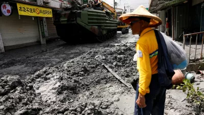 A man stands near a military vehicle on a road filled with mud brought by flooding, after Super Typhoon Ragasa in Hualien, Taiwan, September 24, 2025. REUTERS/Ann Wang   TPX IMAGES OF THE DAY