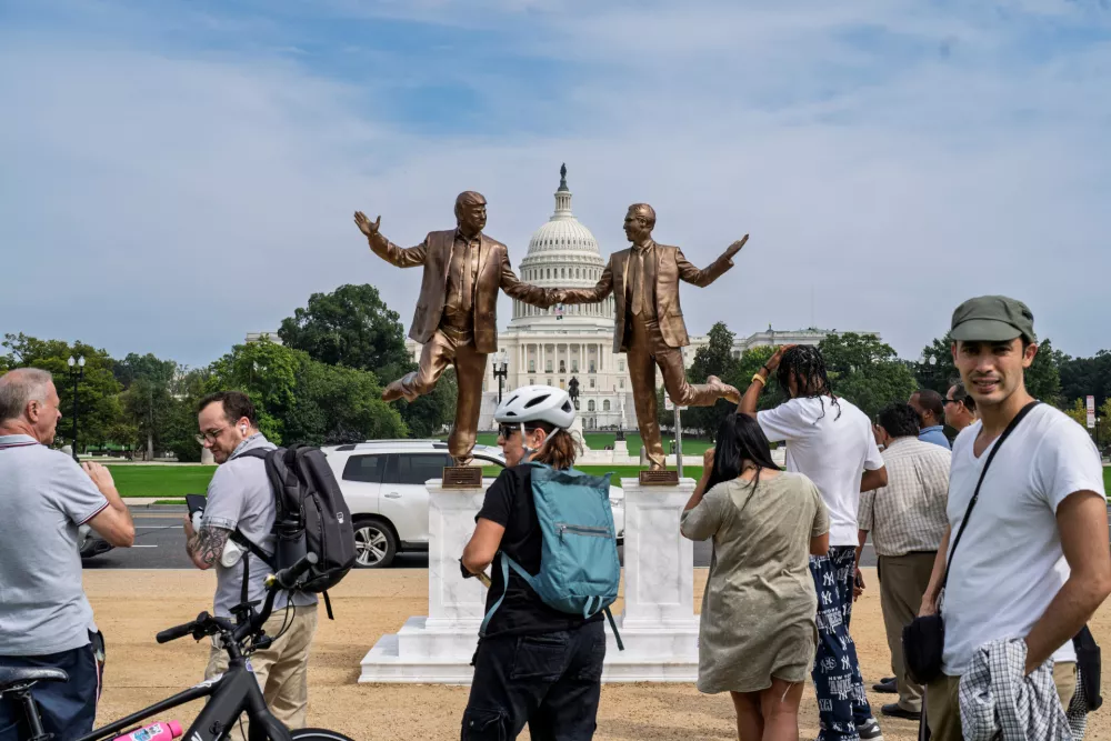 Visitors and free speech activists gather in front of a work of protest art representing President Donald Trump and Jeffrey Epstein, on the National Mall near the Capitol in Washington, Tuesday, Sept. 23, 2025. (AP Photo/J. Scott Applewhite)