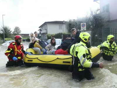 People are rescued by emergency services after heavy rainfall, in Tuscany, Italy, Saturday, Nov. 4, 2023. Record-breaking rain provoked floods in a vast swath of Tuscany as storm Ciarán pushed into Italy overnight. At least six people were killed in that central Italian region. (Adriano Conte/LaPresse via AP)