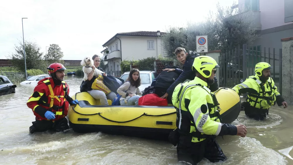 People are rescued by emergency services after heavy rainfall, in Tuscany, Italy, Saturday, Nov. 4, 2023. Record-breaking rain provoked floods in a vast swath of Tuscany as storm Ciarán pushed into Italy overnight. At least six people were killed in that central Italian region. (Adriano Conte/LaPresse via AP)