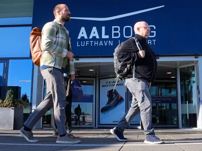Passengers walk past one of the entrances of Aalborg Airport, in Denmark, Thursday, Sept. 25, 2025, after drones were observed on the airport on Wednesday evening and the night to Thursday, and the airspace over the airport was closed. (Bo Amstrup/Ritzau Scanpix via AP)