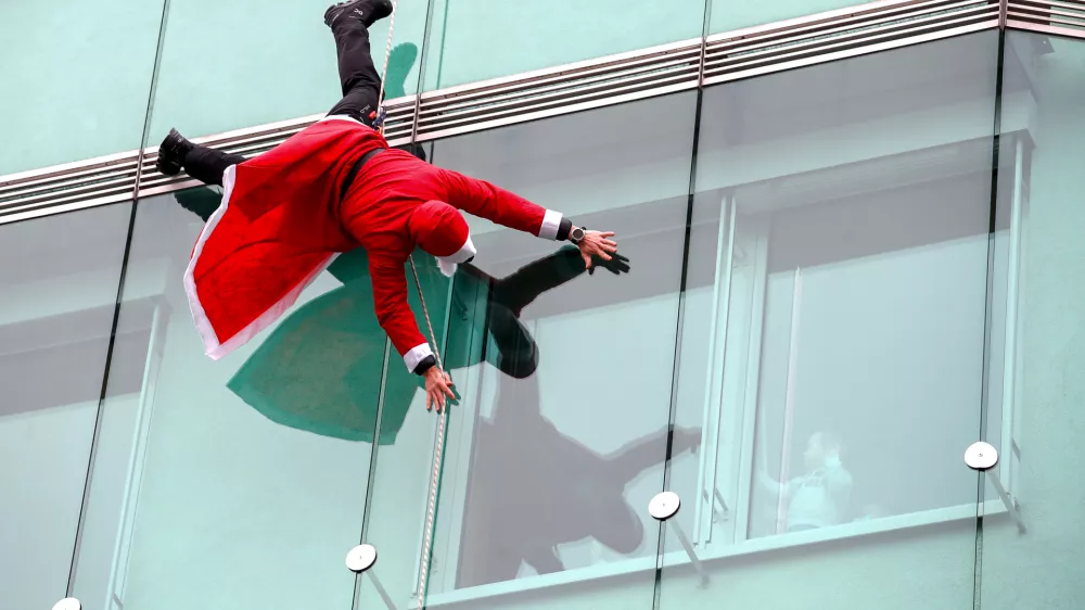 ﻿- 22.12.2021 - Pediatrična klinika - Tradicionalni spust Božičkov s strehe po zunanji strani Pediatrične klinike UKC v Ljubljani - božiček - božički //FOTO: Luka Cjuha