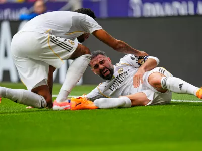 Real Madrid's Dani Carvajal, right, grimaces in pain after being tackled down during the Spanish La Liga soccer match between Atletico Madrid and Real Madrid at Metropolitano stadium, in Madrid, Spain, Saturday, Sept. 27, 2025. (AP Photo/Manu Fernandez)