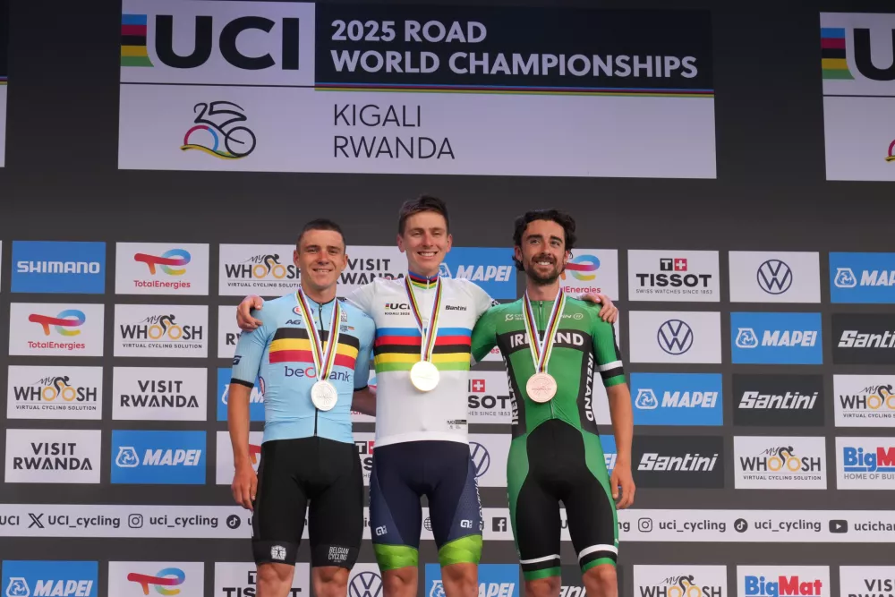 Slovenia's Tadej Pogacar, center, winner of the men's Elite road race, poses on the podium with silver medal's winner Belgium's Remco Evenepoel, left, and bronze medal's winner Ireland's Ben Healy, at the road cycling World Championships in Kigali, Rwanda, Sunday, Sept. 28, 2025. (AP Photo/Jerome Delay)