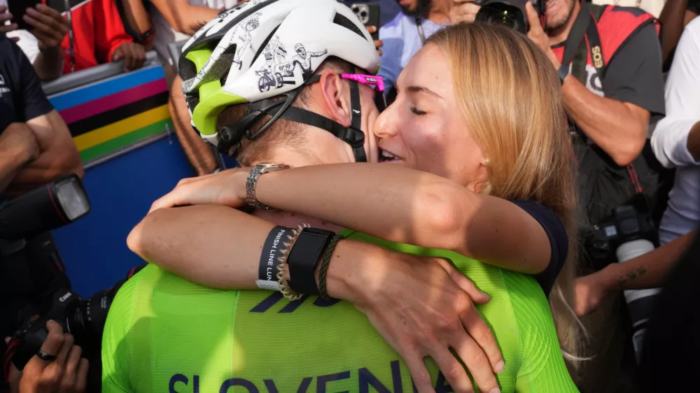 Slovenia's Tadej Pogacar celebrates with his partner Urska Zigart after winning the men's Elite road race, at the road cycling World Championships in Kigali, Rwanda, Sunday, Sept. 28, 2025. (AP Photo/Jerome Delay)