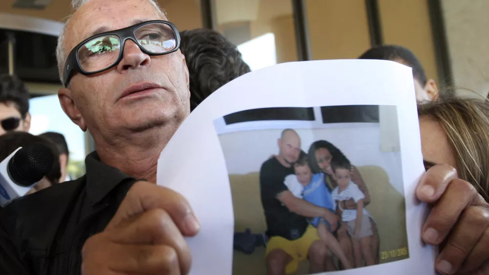 Nelson Marinho holds a photo of his son Nelson Marinho, seen with his family, a passenger on Air France flight 447 that was reported missing on its way from Rio de Janeiro to Paris, at the Windsor hotel in Rio de Janeiro, Wednesday, June 3, 2009. Brazil's military found a 3-mile (5-kilometer) path of wreckage in the Atlantic Ocean, confirming that the jet carrying 228 people crashed in the sea, according to Defense Minister Nelson Jobim. (AP Photo/Patricia Santos)