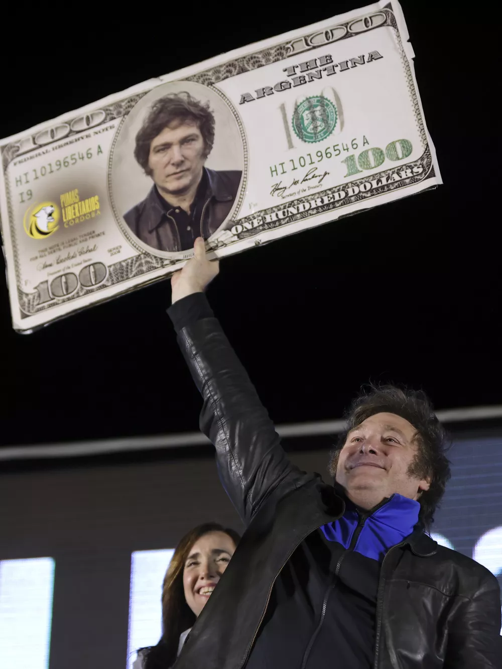 Javier Milei, Liberty Advances coalition presidential candidate, holds a cardboard image of a 100 US dollar bill bedecked with an image of his his face during his closing campaign rally in Cordoba, Argentina, Thursday, Nov. 16, 2023. Milei will face Economy Minister Sergio Massa, the ruling party's candidate, in a runoff election on Nov. 19. (AP Photo/Nicolas Aguilera)