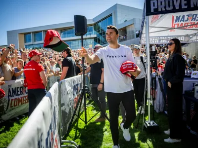 FILE - Charlie Kirk hands out hats before speaking at Utah Valley University in Orem, Utah, Wednesday, Sept. 10, 2025. (Tess Crowley/The Deseret News via AP, File)
