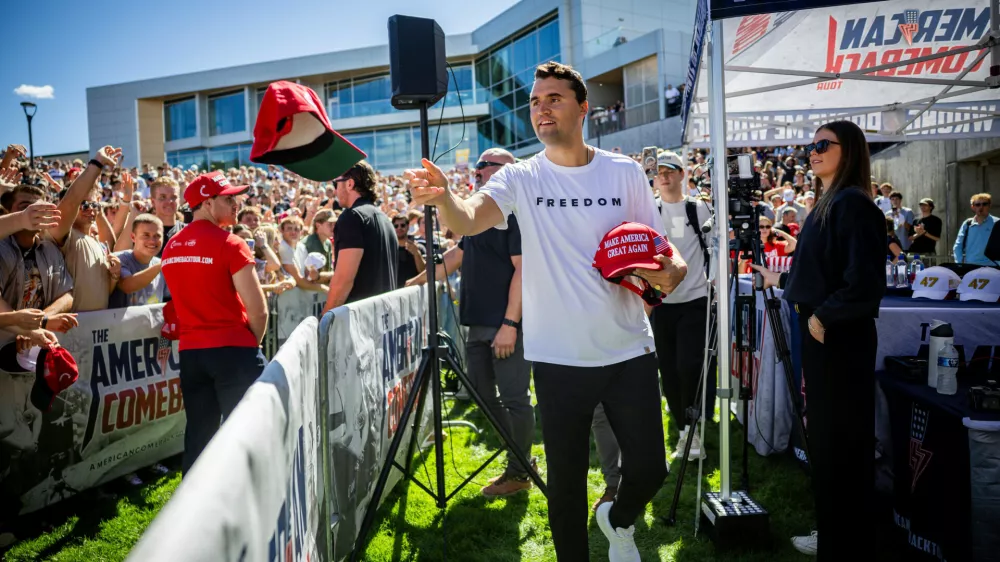 FILE - Charlie Kirk hands out hats before speaking at Utah Valley University in Orem, Utah, Wednesday, Sept. 10, 2025. (Tess Crowley/The Deseret News via AP, File)