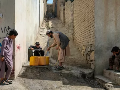 Shopkeeper Assadullah collects water from a neighbour's tap, amid serious water crisis in Kabul, Afghanistan, September 14, 2025. REUTERS/Sayed Hassib