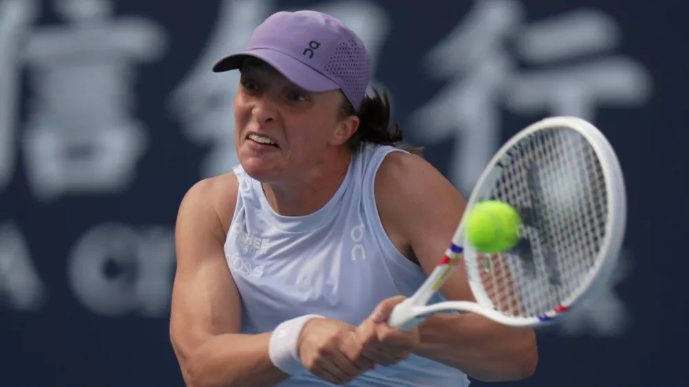 Iga Swiatek, of Poland plays a backhand return to Camila Osorio, of Colombia during the women's singles match for the China Open tennis tournament, at the National Tennis Center, in Beijing, Monday, Sept. 29, 2025. (AP Photo/Andy Wong)
