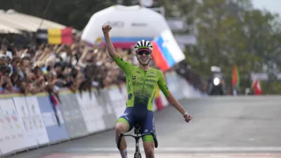 Slovenia's Tadej Pogacar celebrates winning the men's Elite road race, at the road cycling World Championships in Kigali, Rwanda, Sunday, Sept. 28, 2025. (AP Photo/Jerome Delay)
