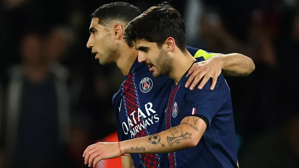 Soccer Football - Ligue 1 - Paris St Germain v AJ Auxerre - Parc des Princes, Paris, France - September 27, 2025 Paris St Germain's Lucas Beraldo celebrates scoring their second goal with Achraf Hakimi REUTERS/Sarah Meyssonnier