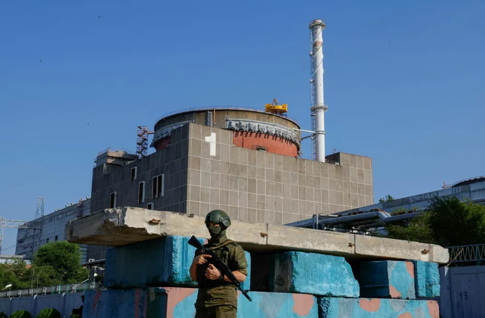 FILE PHOTO: A Russian service member stands guard at a checkpoint near the Zaporizhzhia Nuclear Power Plant before the arrival of the International Atomic Energy Agency (IAEA) expert mission in the course of Russia-Ukraine conflict outside Enerhodar in the Zaporizhzhia region, Russian-controlled Ukraine, June 15, 2023. REUTERS/Alexander Ermochenko/File Photo