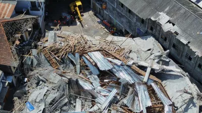 This aerial shot taken with a drone shows rescuers searching for victims trapped under the rubble after a building under construction collapsed Monday at an Islamic boarding school in Sidoarjo, East Java, Indonesia, Wednesday, Oct. 1, 2025. (AP Photo/Trisnadi)