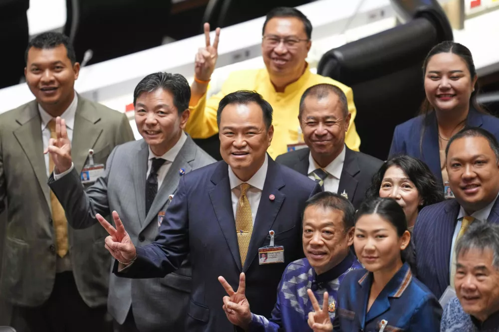 Thailand's Prime Minister Anutin Charnvirakul, center, reacts with lawmakers before he presents the policy statement at the parliament in Bangkok, Thailand, Monday, Sept. 29, 2025. (AP Photo/Sakchai Lalit)