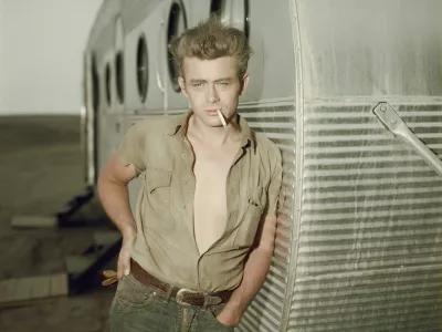 circa 1955: American actor James Dean (1931 - 1955) leaning against a dressing room trailer with his shirt open to the waist while smoking a cigarette on the set of director George Stevens's film, 'Giant,' in which he starred. (Photo by Hulton Archive/Getty Images) / Foto: Hulton Archive