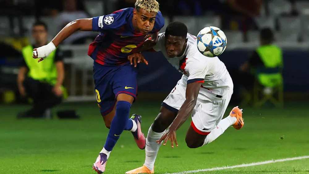 Soccer Football - UEFA Champions League - FC Barcelona v Paris St Germain - Estadi Olimpic Lluis Companys, Barcelona, Spain - October 1, 2025 FC Barcelona's Lamine Yamal in action with Paris St Germain's Nuno Mendes REUTERS/Albert Gea
