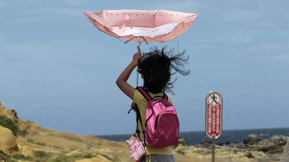 ﻿A girl struggles with winds from approaching Typhoon Matmo along the eastern coast of Keelung, northeastern Taiwan, Tuesday, July 22, 2014. The eye of Typhoon Matmo is expected to make landfall in eastern Taiwan early Wednesday bringing heavy rain and winds with gusts over 130 kilometers (85 miles) per hour. (AP Photo/Wally Santana)
