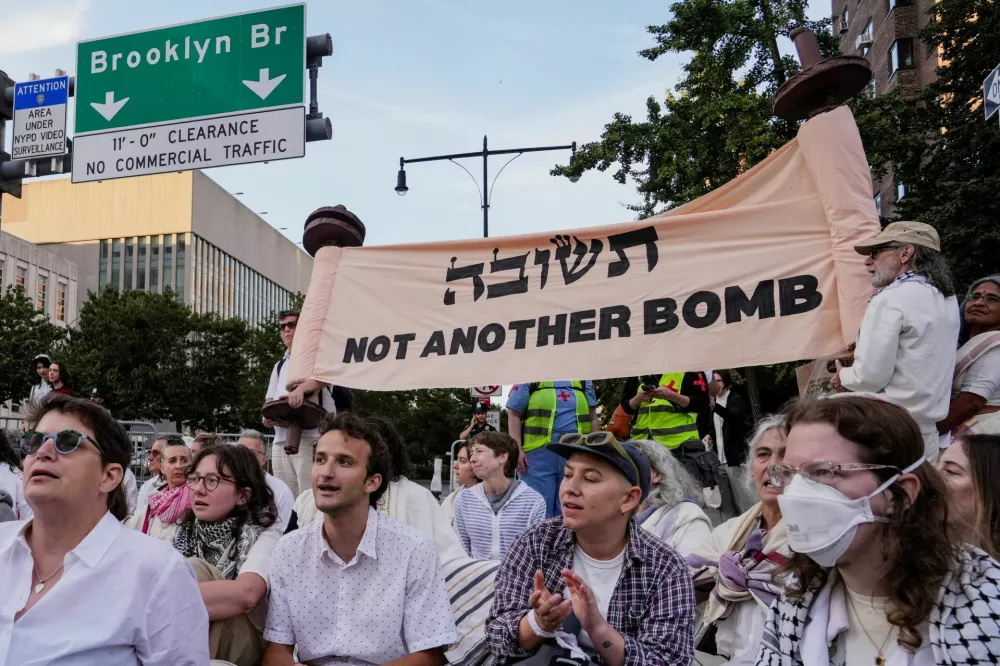 People participating in the Yizkor ritual for Yom Kippur, the holiest day in the Jewish calendar, block the Brooklyn side of the Brooklyn Bridge to protest against Israel's military action in Gaza, in New York, U.S., October 2, 2025. REUTERS/Adam Gray