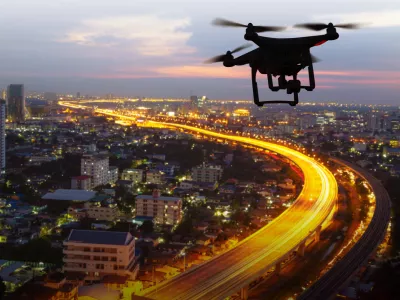 Silhouette of drone flying above city at sunset / Foto: Naypong