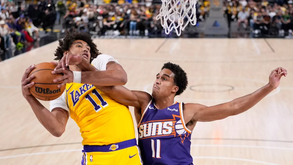 Los Angeles Lakers center Jaxson Hayes, left, grabs a rebound away from Phoenix Suns center Oso Ighodaro during the second half of an NBA preseason basketball game Friday, Oct. 3, 2025, in Palm Desert, Calif. (AP Photo/Mark J. Terrill)